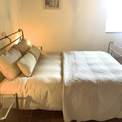Bed in ouderslaapkamer in appartement Camino, opgemaakt